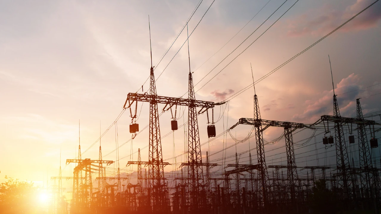 Electricity pylons against a sunset.