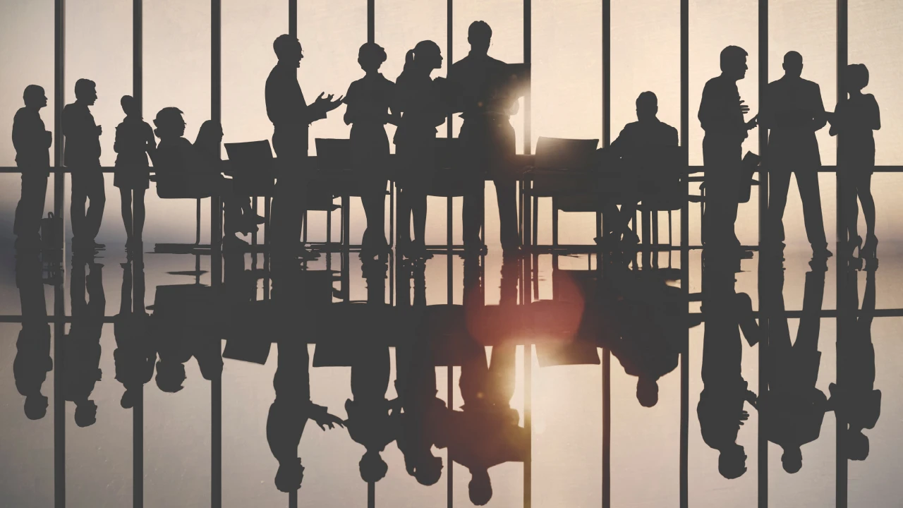 Silhouetted business-people networking.