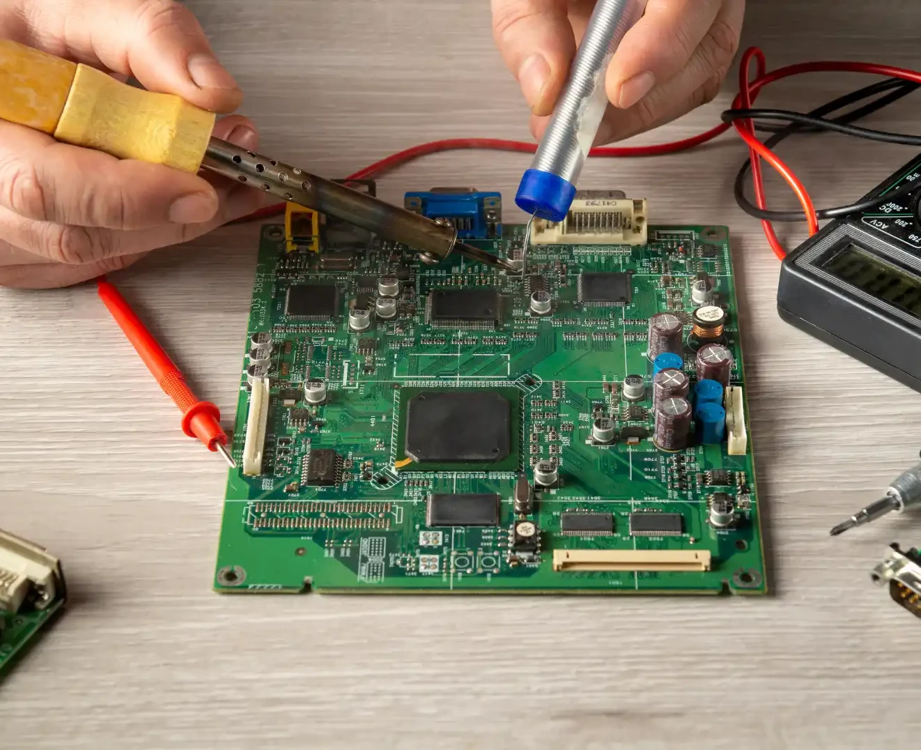 A worker is building a motherboard component in a manufacturing facility