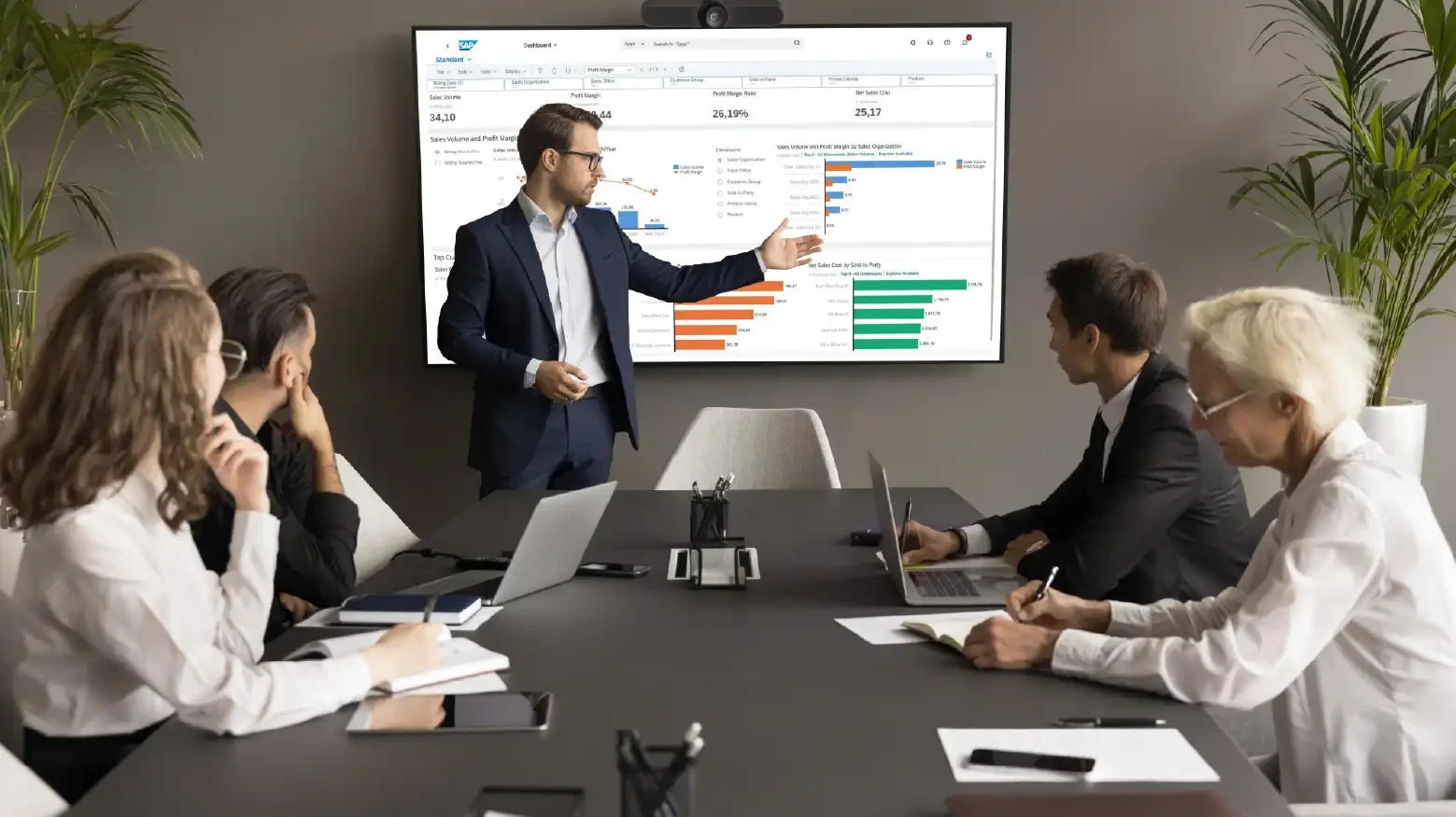 Confident young business leader man presenting marketing statistic report to partners, investors, selling startup project on meeting, negotiations, showing graphs on electronic display