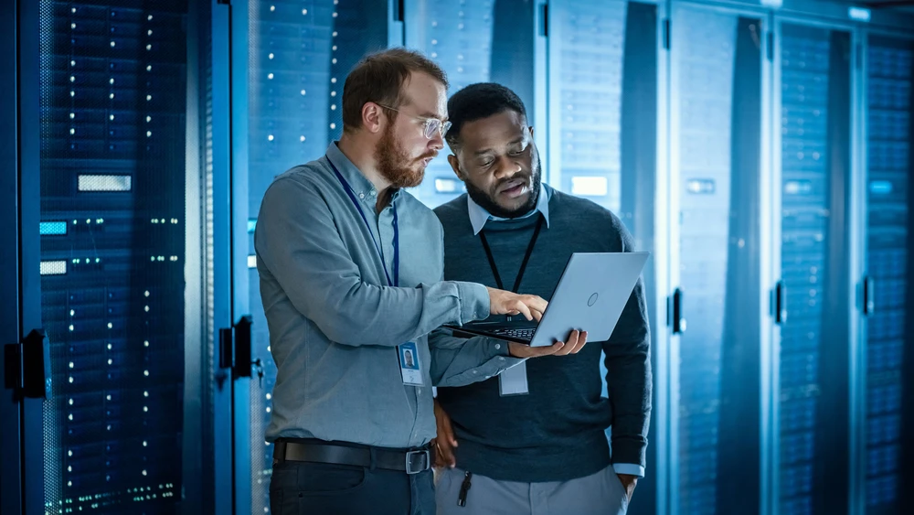 Two colleagues laptop cyber data centre server racks