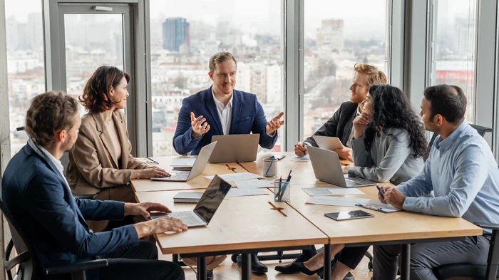 Team of finance specialists in the office with their computers and potential customer