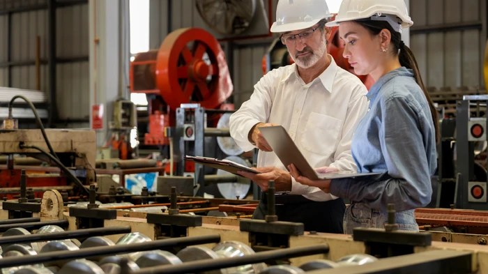 Two men and a woman working in a paper mill on a computer with 360-degree visibility for strategic decision making.