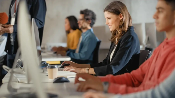 Woman working on computer with value-packed deliverables that will empower you at every step of your journey from Oracle Forms to Oracle APEX.