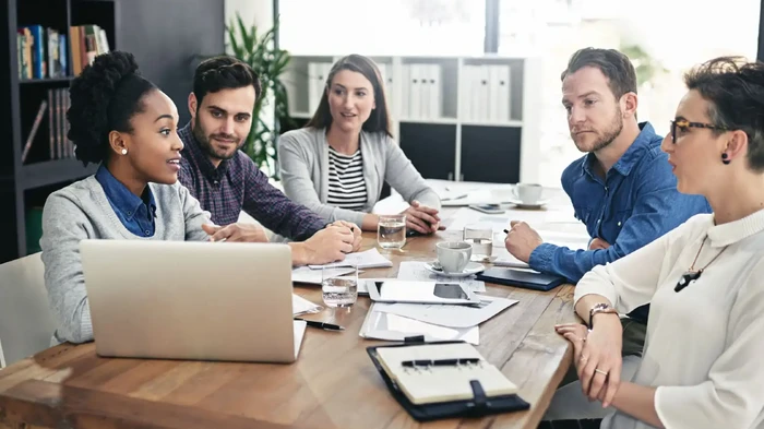 Company, meeting and business people with laptop in office for strategy, brainstorming or review.