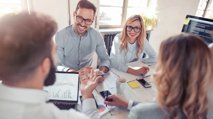 Business colleagues in modern office using tablet-sales