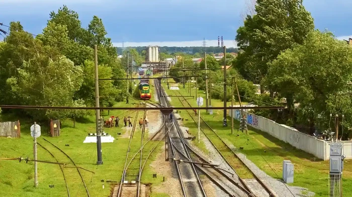 A train track breaks into two path as a fork in the road appears