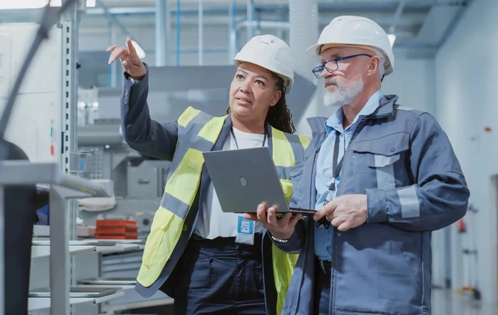 Two Heavy Industry Employees in Hard Hats at Factory.