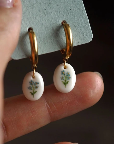 Clay earrings with forget me not drawing