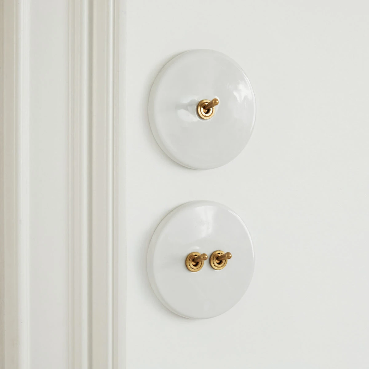 Interrupteur blanc porcelaine et laiton