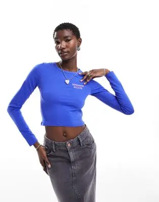 Monki - Crop top à manches longues avec imprimé Kindness positionné - Bleu vif