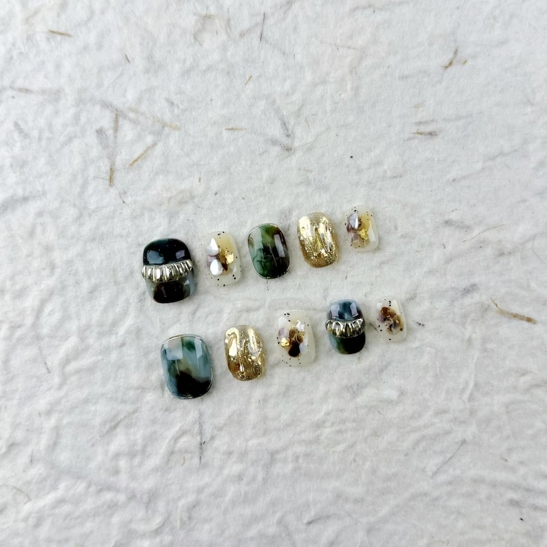 Ongles à presser carrés courts et élégants dans un dégradé de vert foncé à noir avec des accents métalliques, des reflets dorés/argentés et des