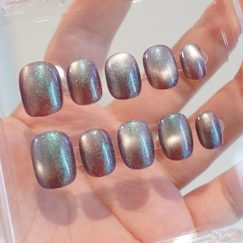 Paillettes bleues scintillantes, oeil de chat blanc, ongle court carré rond marron, ongles d'automne et d'hiver