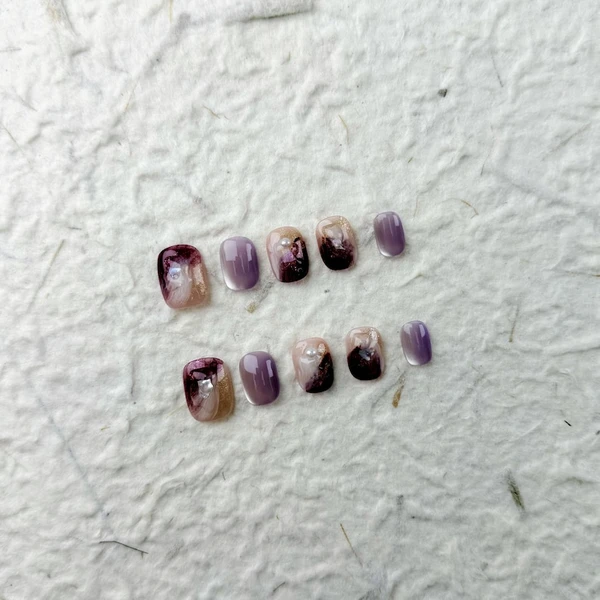 Ongles pressés carrés courts raffinés en rose nude et violet, ornés de perles et de strass. Parfait pour les fêtes et les occasions spéciales