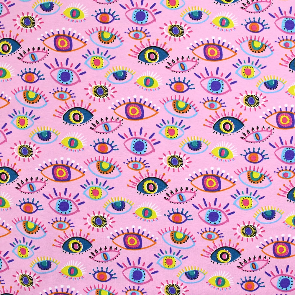 Jersey de coton imprimé yeux multicolores fond rose clair