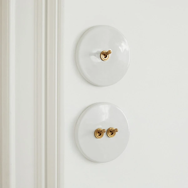 Interrupteur blanc porcelaine et laiton