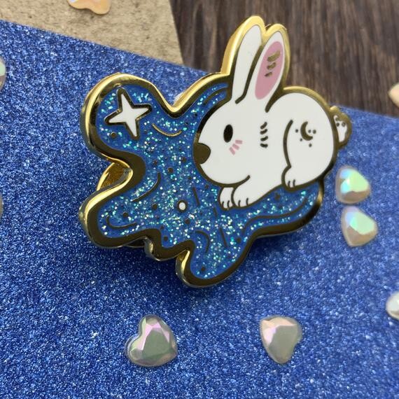 Pin doré emaillé de lapin mignon dans un ciel bleu pailleté