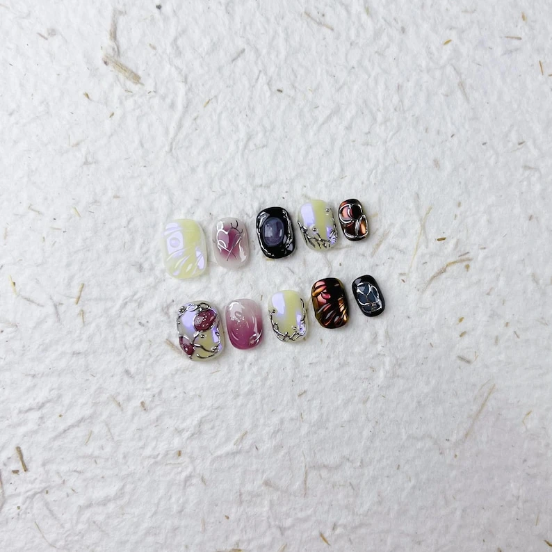 Presse carrée courte unique sur les ongles avec des lignes rouges et argentées et des motifs ovales violets. Un design audacieux pour les fêtes ou un