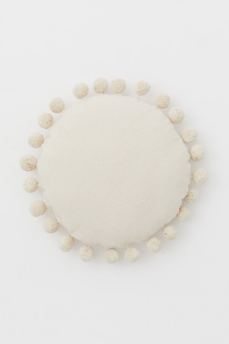 Coussin rond avec pompons