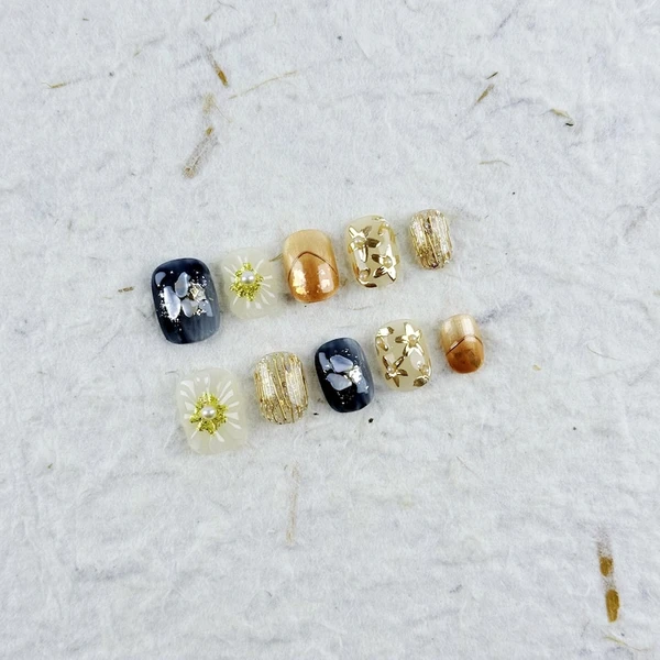 Presse-ongles carrés luxueux et courts en noir, or et cuivre avec des fleurs 3D, des perles et des accents métalliques, parfait pour les événements