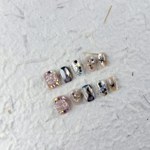 Ongles courts et luxueux à presser avec base rose nude, gaufrage 3D et cristaux colorés, faux ongles parfaits pour les fêtes et les événements glamour