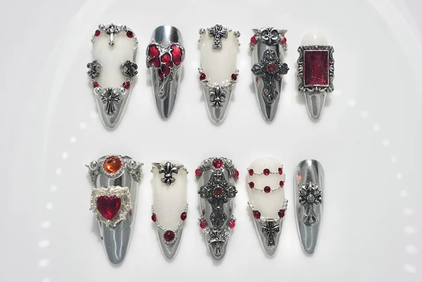 Presse gothique 3D sur les ongles | Chrome argenté, pierres précieuses rouges et breloques croix | Faux ongles faits main en amande | Style gothique
